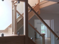 Glass stair panels with wooden handrail and steel clamps in Berkhamstead